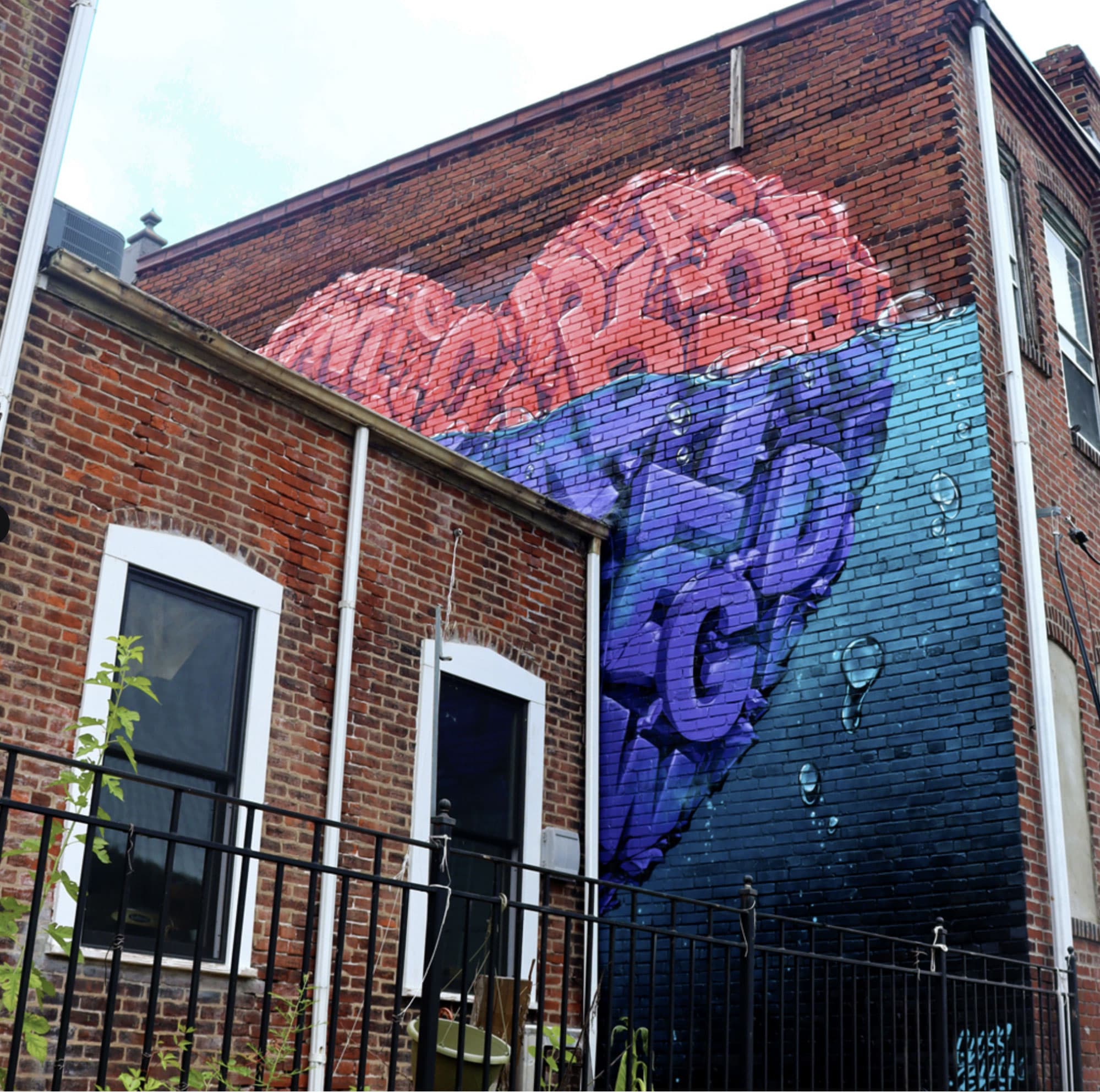 A large, colorful heart mural painted on a brick wall.